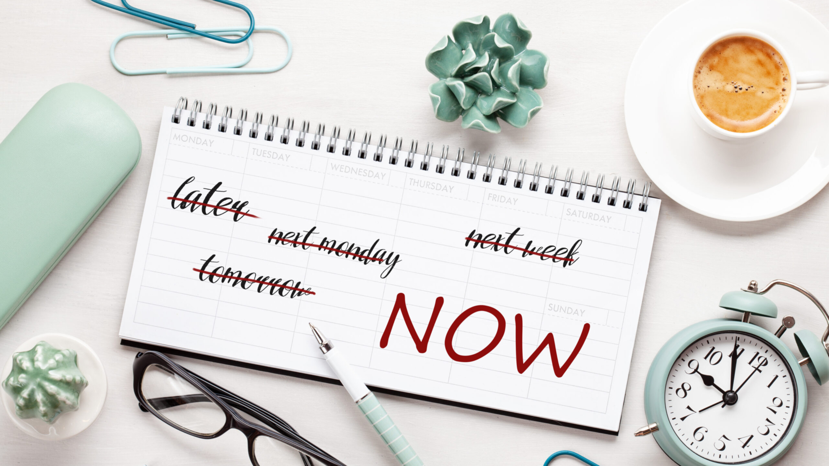 Time management concept with notes in weekly organizer over the desk with coffee and alarm clock.