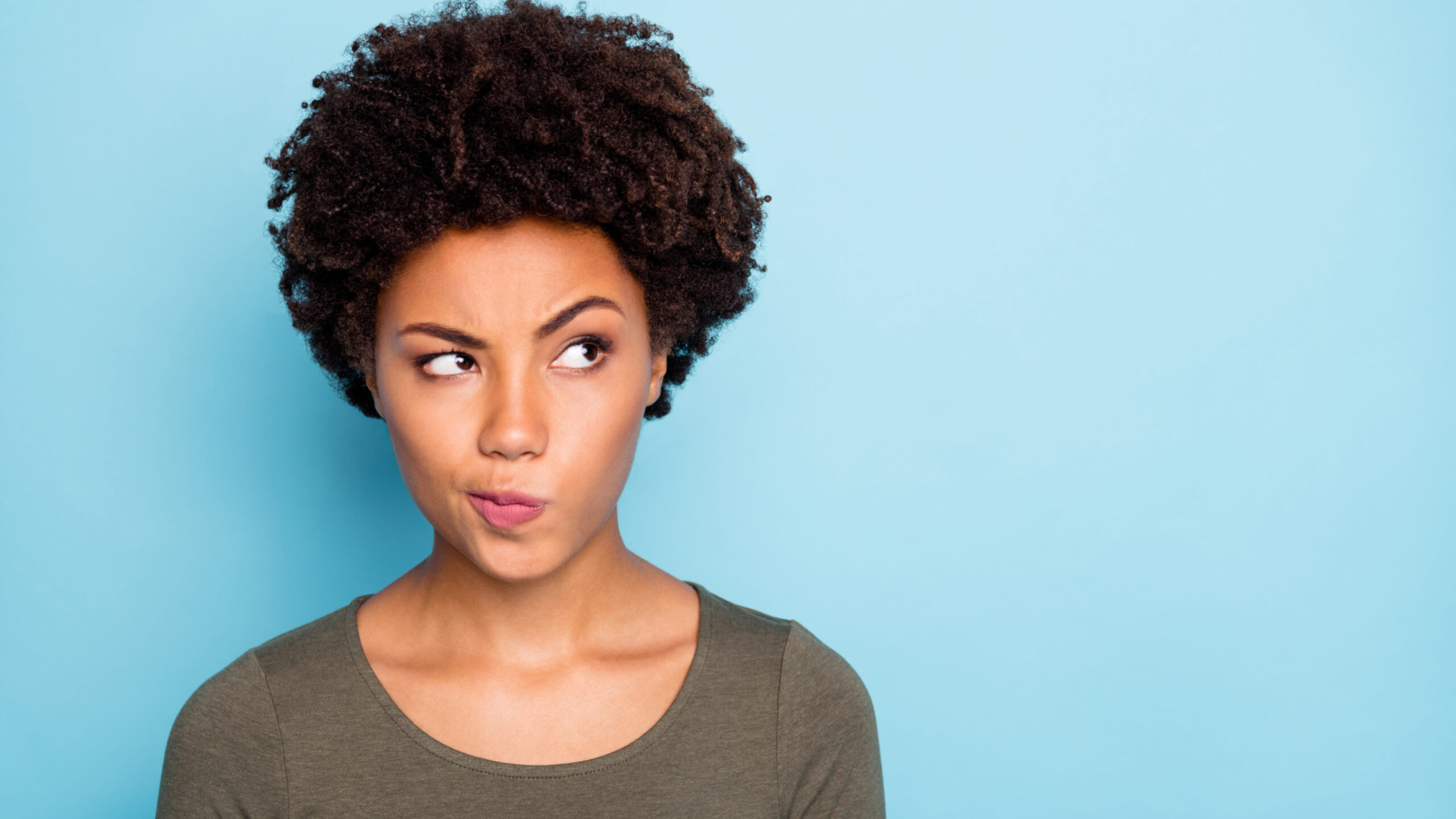 Hmm... interesting. Portrait of serious expression emotions minded afro american girl think try to solve decide solutions be creative, wear good look outfit isolated over blue color background